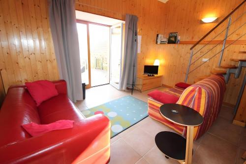 Chant De La Fontaine - La Fougère في Saint-Laurent-les-Bains: غرفة معيشة مع أريكة حمراء وطاولة