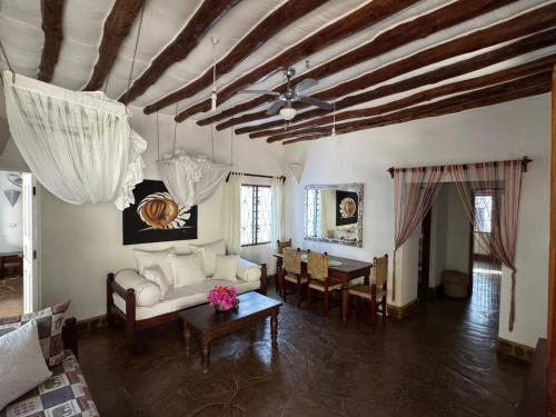 un soggiorno con un divano e un tavolo di Charming Cottage in Watamu a Watamu