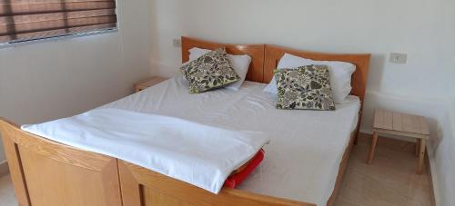 Una cama con dos almohadas encima en una habitación. en Alnwatif Gate guest house Dana nature reserve, en Dana