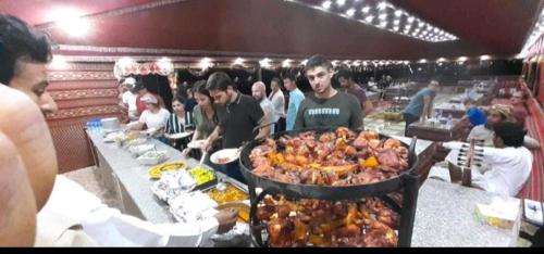un gruppo di persone sedute a un buffet con del cibo di Wadi Rum Bubble Dream a Wadi Rum