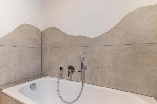 策尔阿姆哈尔梅尔斯巴赫Im Rosengarten 3的浴室设有带淋浴喷头的浴缸。