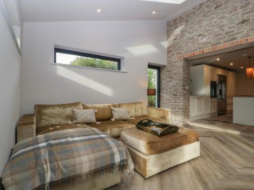 een woonkamer met een bank en een tafel bij Tawny Cottage in Llandenny