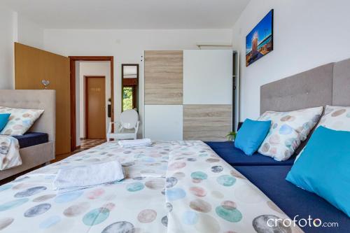 una camera da letto con un letto grande con cuscini blu di Villa Mavi a Drežnik Grad