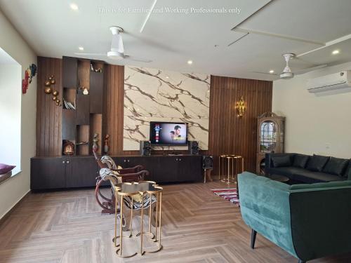 een woonkamer met een bank en een tv bij 2 Bedroom Serviced Home in Lahore