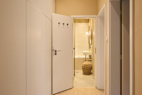 a bathroom with a white door and a sink at Flamingo Flat - Prague in Prague