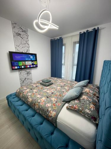 a bedroom with a large bed with a blue couch at App Town North Pipera 23 in Voluntari