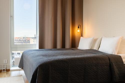ein Schlafzimmer mit einem Bett mit einem großen Fenster in der Unterkunft Forenom Aparthotel Luleå Västra Stranden in Luleå