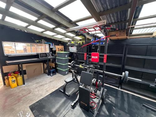 a room with a gym with a bench press at South Dudley Beach House - Pet friendly in Dudley South