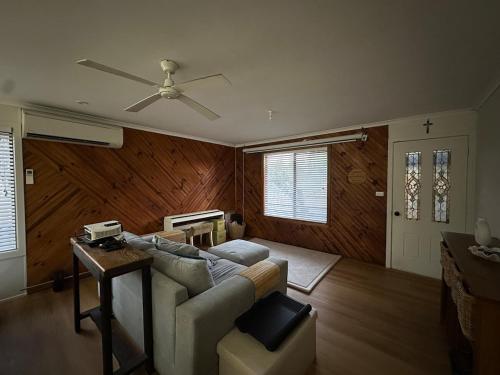 a living room with a couch and a ceiling fan at South Dudley Beach House - Pet friendly in Dudley South