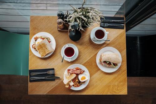 una mesa con platos de comida y tazas de café en New Port Aparthotel, en Cracovia