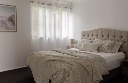 En eller flere senge i et værelse på Coastal Comfort