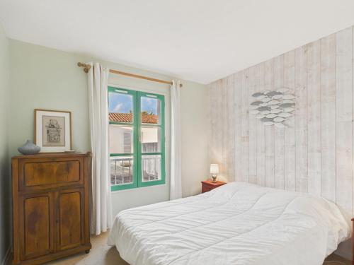 a white bedroom with a bed and a window at Au coeur du port, vue unique, appartement pour 6 in Saint-Martin-de-Ré