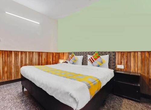 a bedroom with a large bed with wooden walls at LIMRA INN RESIDENCY cottage in Ooty