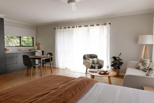 een woonkamer met een bed, een bank en een tafel bij Saltbush Retreat in Nelson Bay