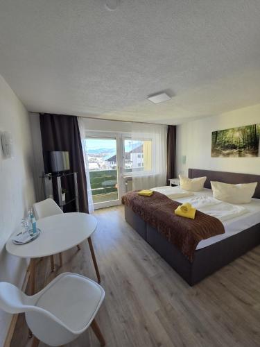 a bedroom with a large bed and a table and chairs at Landhotel Röfleuten in Pfronten
