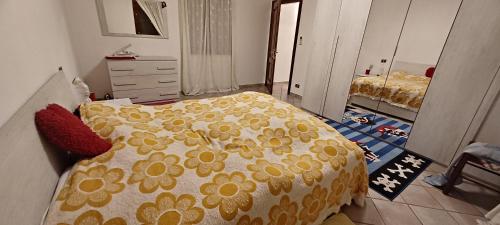 ein Schlafzimmer mit einem Bett mit einer gelben und weißen Bettdecke in der Unterkunft Villa Polesine in Porto Tolle