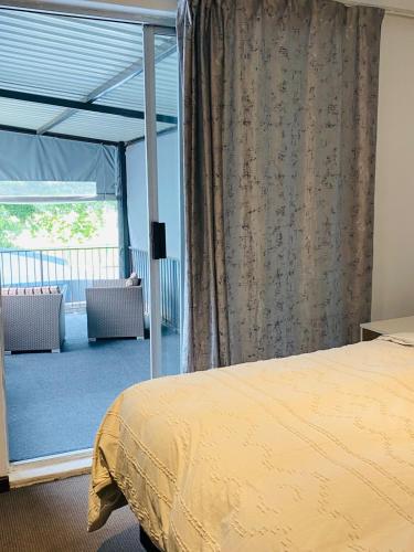 a bedroom with a bed and a large window at Linies guest house northmead in Benoni
