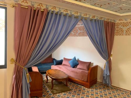 ein Wohnzimmer mit Sofa und Tisch in der Unterkunft Diyafat Bladi in Oujda