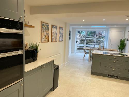 a kitchen with a sink and a stove top oven at Luxury Lechlade cottage - Character and charm in Lechlade