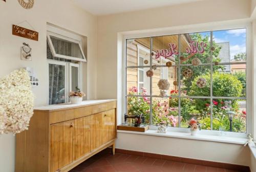 a kitchen with a window with flowers in it at Vila Liepa in Birštonas