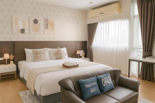 a hotel room with a large bed and a couch at City Center Nana 4-Guest Suite 100m Nana BTS in Bangkok
