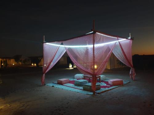 a tent with lights on it in the dark at Tenere Luxury Camp in Merzouga
