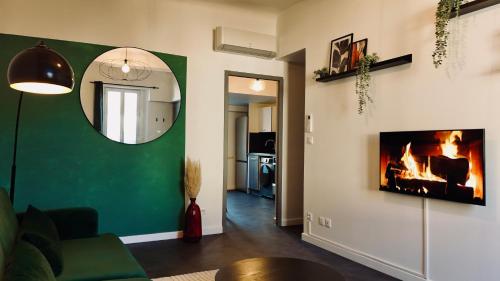布里尼奥勒Juni - Climatisé & Balconnet的带壁炉和镜子的客厅