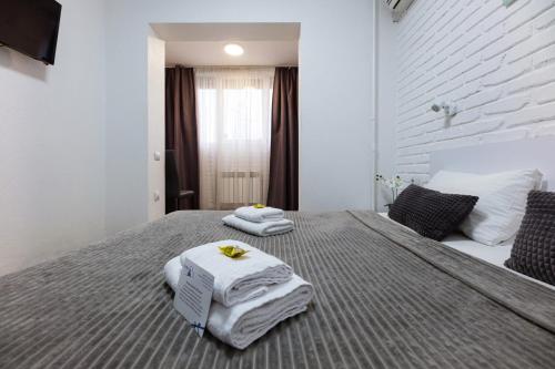 Un dormitorio con una cama con toallas. en SkyHome na Nauky, en Kiev