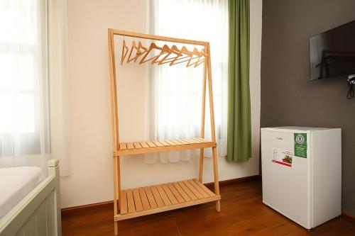 艾瓦勒克Defne Pansiyon Ayvalık的一间设有书架和小冰箱的客房