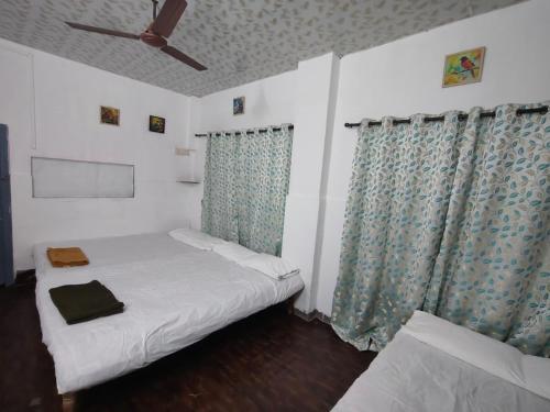 a bedroom with a bed and a ceiling fan at Patil villa in Nagaon