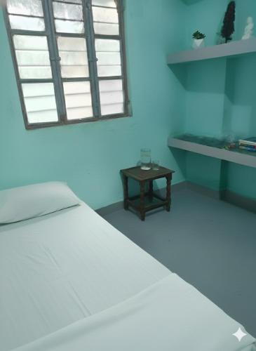 穆扎夫法尔普尔santosh lodge的卧室里有一张白色的床和一张桌子