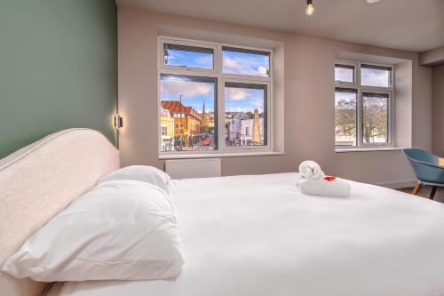 a bedroom with a white bed with a stuffed animal on it at Cosy serviced flat in Westbury on Trym in Bristol