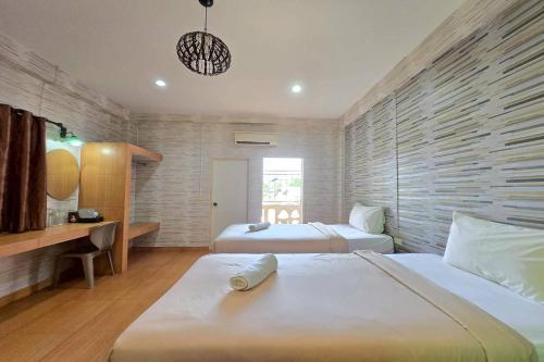 um quarto com duas camas e uma escrivaninha em SK Hotel Phitsanulok em Ban Nong Chaeng