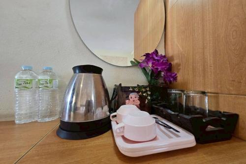 um balcão com uma cafeteira e xícaras sobre uma mesa em SK Hotel Phitsanulok em Ban Nong Chaeng