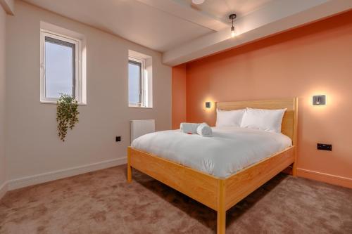 a bedroom with a bed and two windows at High Street Hideaway, private entrance, parking in Bristol