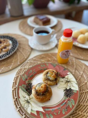 een tafel met borden en een fles sinaasappelsap bij Rancho Palmeira Jardim in Formosa