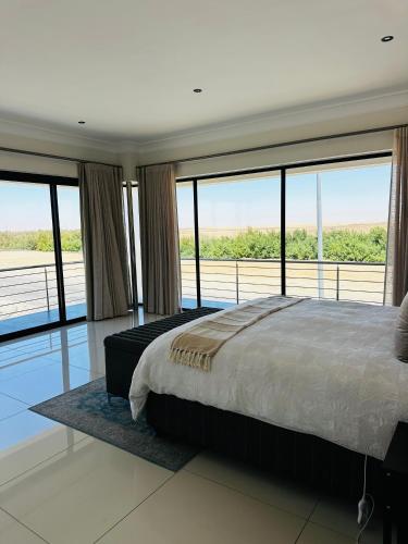 una camera da letto con un letto grande e grandi finestre di Duinen Suites a Walvis Bay