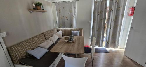 ein Wohnzimmer mit Tisch und Couch in der Unterkunft Vomer Beachside Unit in Pakoštane