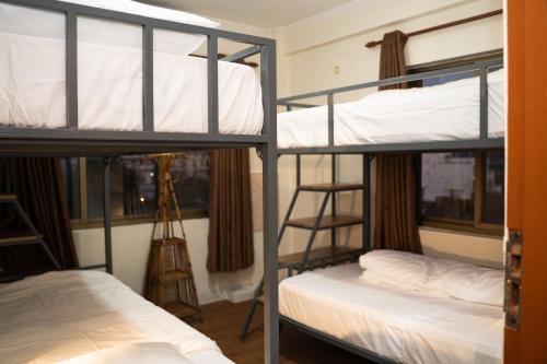a room with three bunk beds and a window at Aarya Wellness & Hostel in Kathmandu