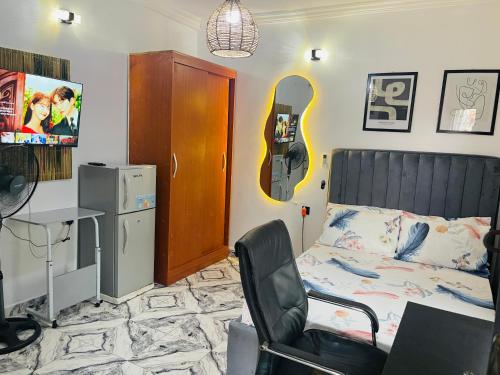 een kamer met een bed, een bureau en een stoel bij Private Studio Apartment in Lagos