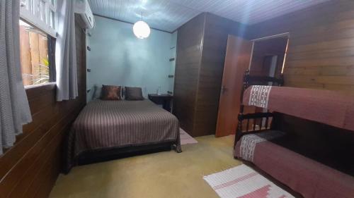 a small bedroom with a bed and a window at Apartamento Residencial Recanto Da Ferrugem in Garopaba