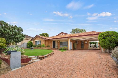 a house with a brick driveway in a yard at Entire House with 4 bedrooms Fully Air Conditioned in Perth