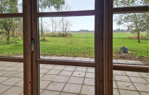 Børglum3 Bedroom Cozy Home In Vrå的一扇敞开的玻璃门，窗外是一片田野。