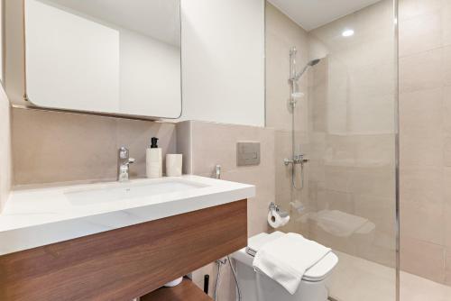 un bagno con lavandino e doccia di VayK - Chic 2BR in Town Square with Pool View a ‘Ūd al Bayḑāʼ
