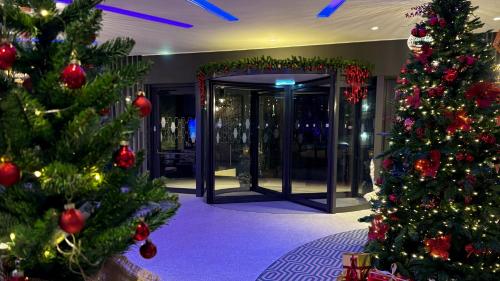 a christmas display of christmas trees in a lobby at Hampton By Hilton Venice Isola Nuova in Venice