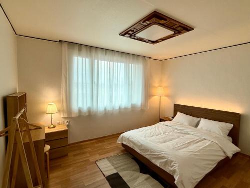 平泽市Slow Stay in camp humphreys的一间卧室，配有一张大床和一扇窗户。