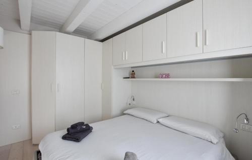1 dormitorio con 1 cama blanca y armarios blancos en Stunning Apartment In Temù With House A Mountain View, en Temù