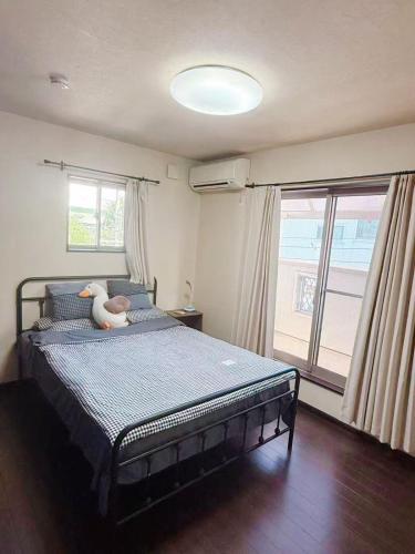 a bedroom with a bed with a stuffed animal on it at hibiki hotel osaka in Osaka