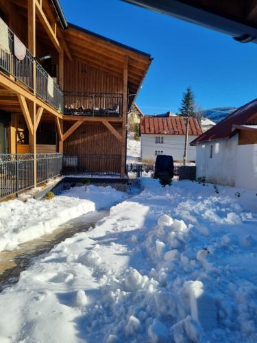 un patio cubierto de nieve frente a una casa en Luxusný apartmán Karolína, en Telgárt