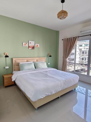 a bedroom with a large bed and a window at Calm Stay & Cafe in Chiang Mai